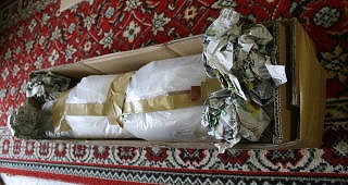 　発送用箱に包まれた魚とクッション用新聞紙